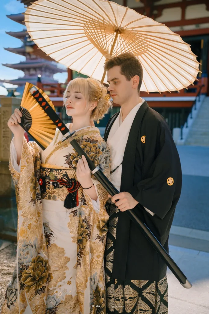 Couple in premium furisode and men's montsuki at Sensoji Temple, Asakusa Tokyo — holding wagasa and katana
