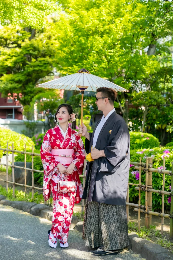 Couple in traditional kimono and men's montsuki hakama at Sensoji Temple, Asakusa Tokyo — man holding wagasa