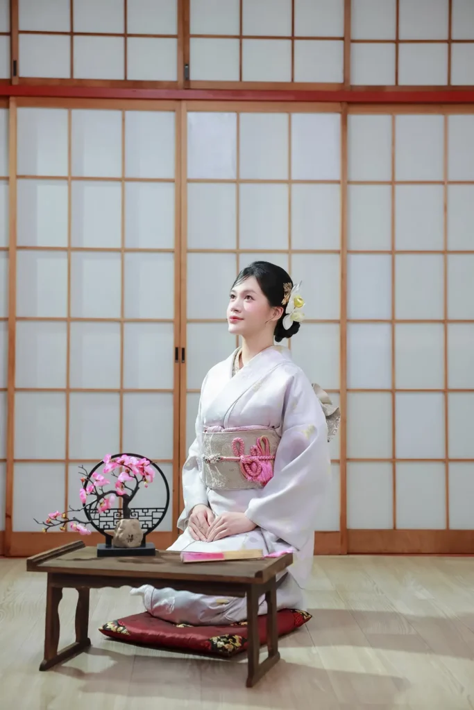 oman in lilac kimono seated at a low table during an indoor kimono photoshoot in the shoji-lit studio at Kimono Rental Ann, Asakusa