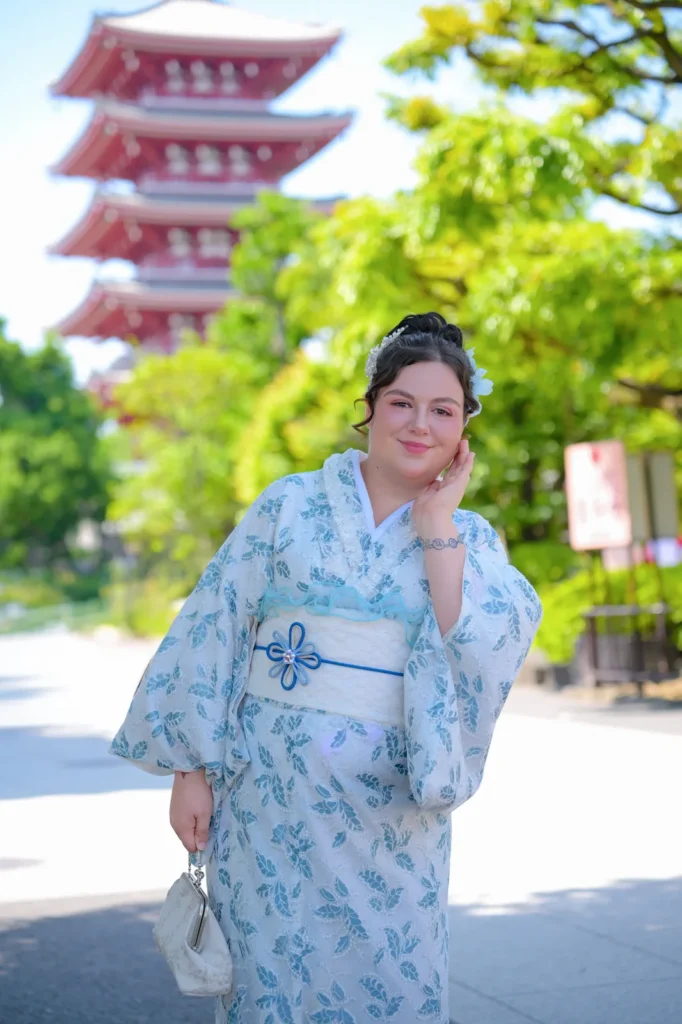 Woman in a pale blue lace plus size kimono in front of the five-story pagoda at Sensoji Temple, Asakusa