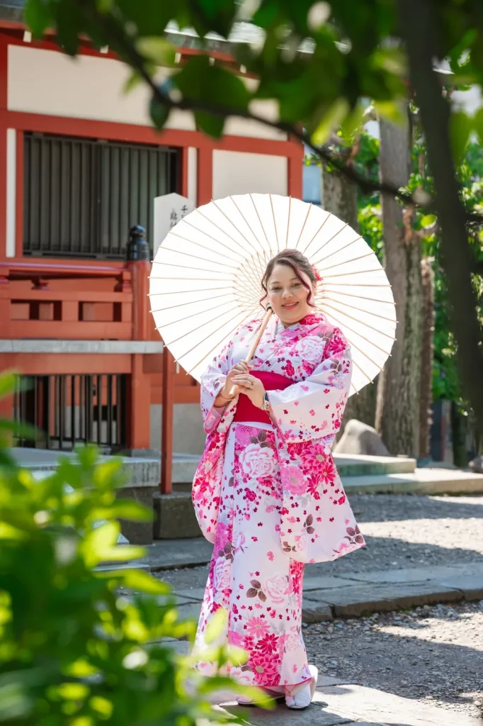 Pink and white floral plus size kimono with a white wagasa parasol in the Asakusa shrine garden