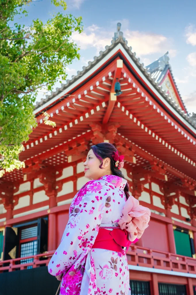 Back view of a pink cherry blossom plus size kimono with an organza obi bow at Sensoji Temple main hall