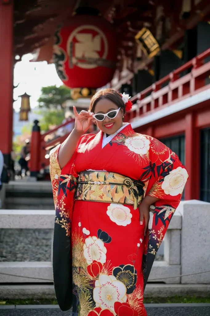 Red plus size furisode with gold obi and cat-eye sunglasses under the Sensoji lantern in Asakusa