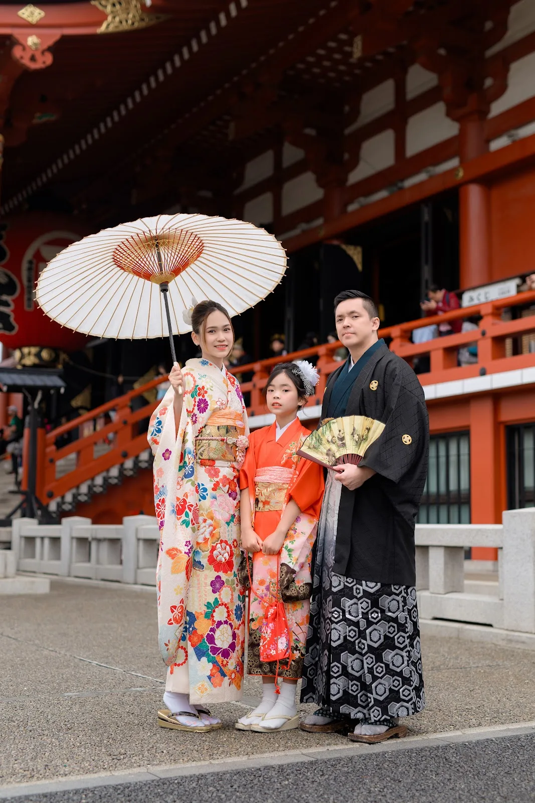 Family with a young daughter and a paper umbrella in front of the Sensoji Main Hall