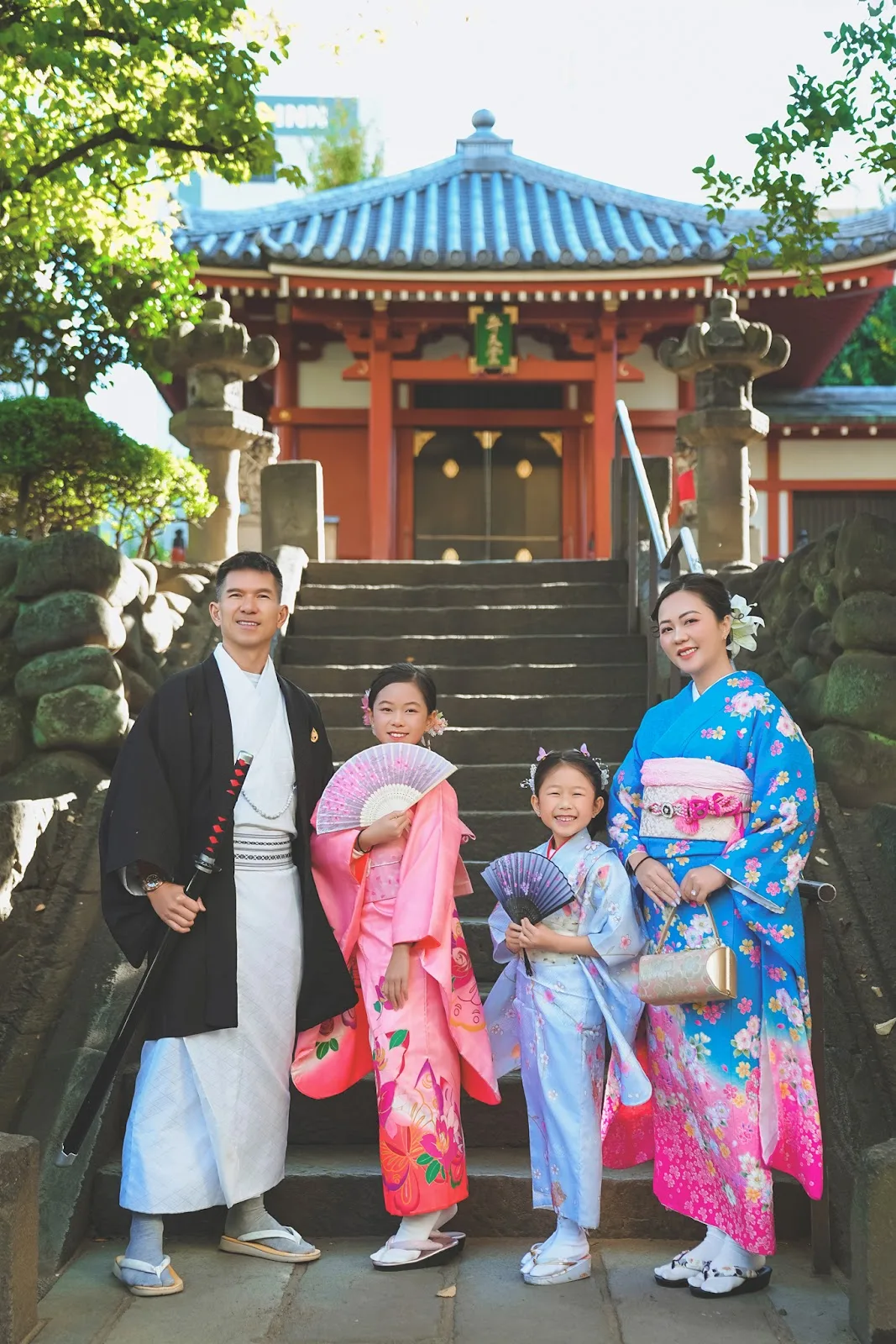 Family of four in kimono on the stone steps of Benten-do, Asakusa
