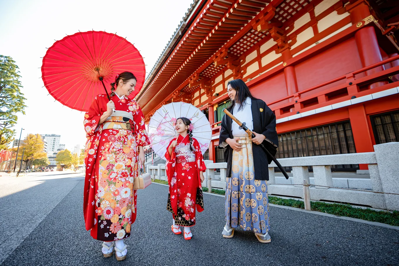 Family walking with red paper umbrellas at Sensoji Temple, Asakusa