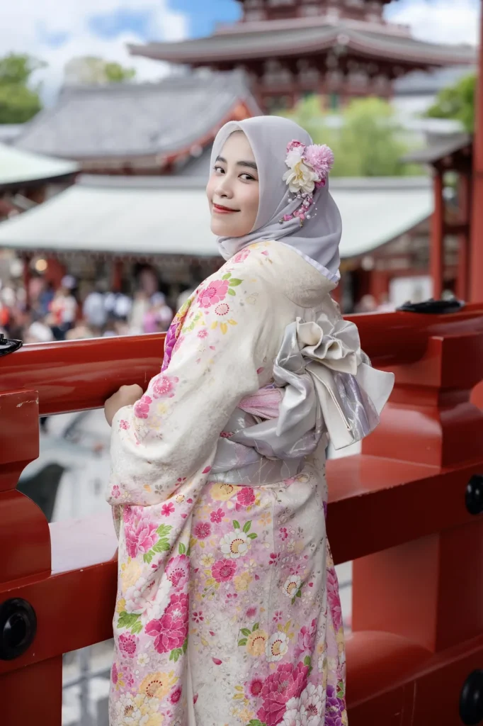 Pink flowers pinned on a soft grey hijab with a pink floral kimono, five-storied pagoda behind, Asakusa