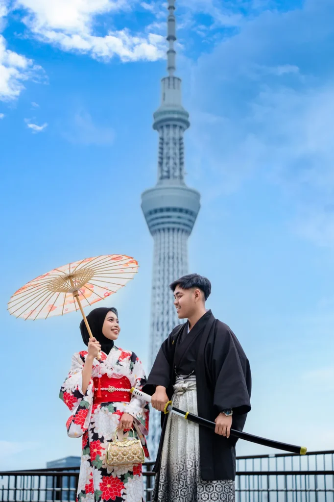 Black hijab with a red, white and black floral kimono and paper parasol in front of Tokyo Skytree