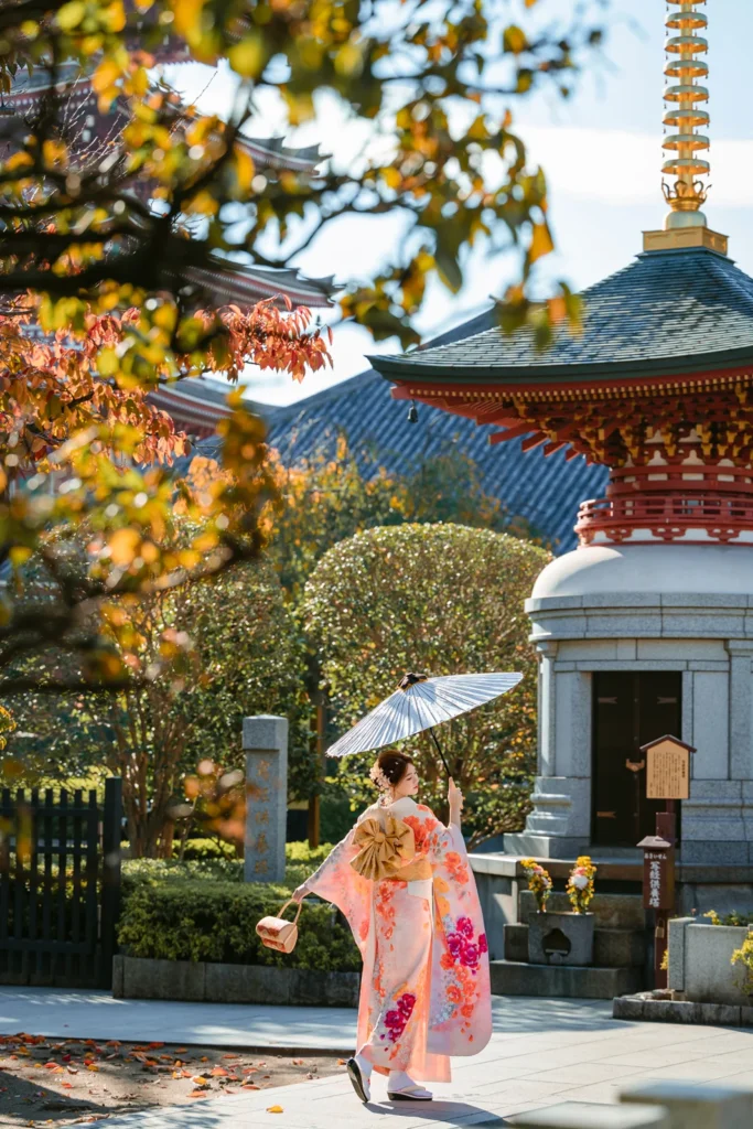 Guest in a pink kimono with a white parasol in the garden of Awashimado Hall in autumn, Asakusa