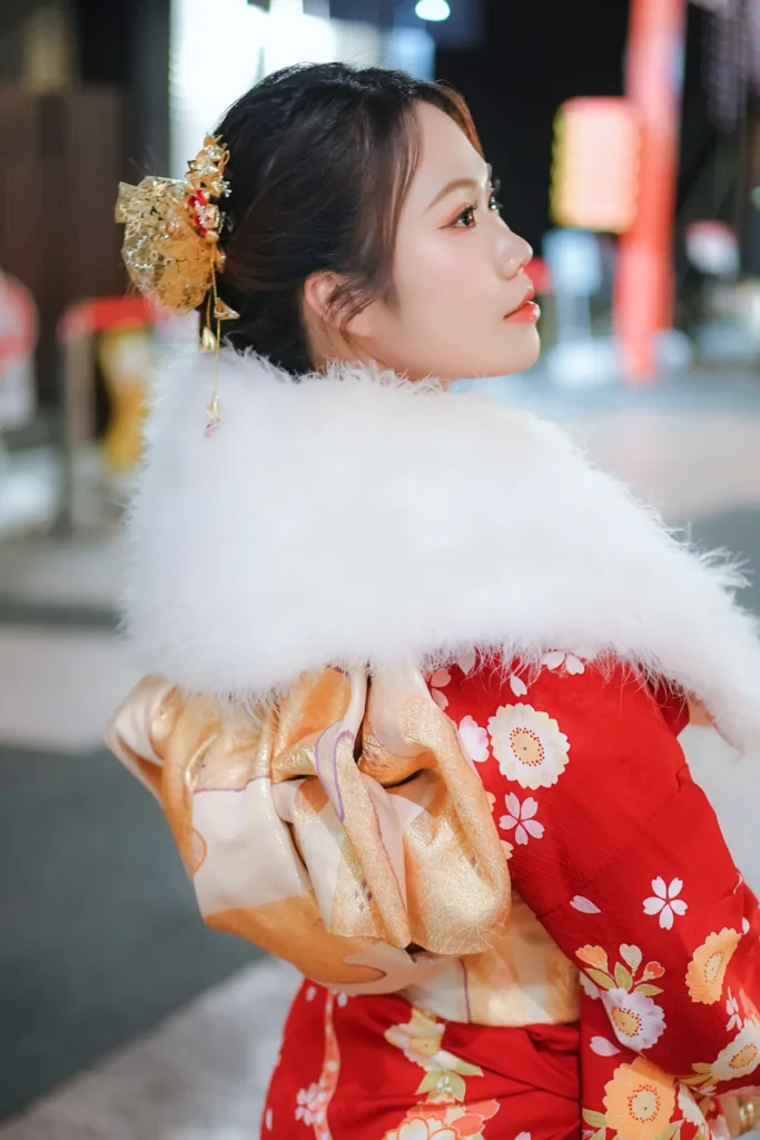 Back view of a red furisode with a gold obi and white fur winter shawl, kimono rental in Asakusa